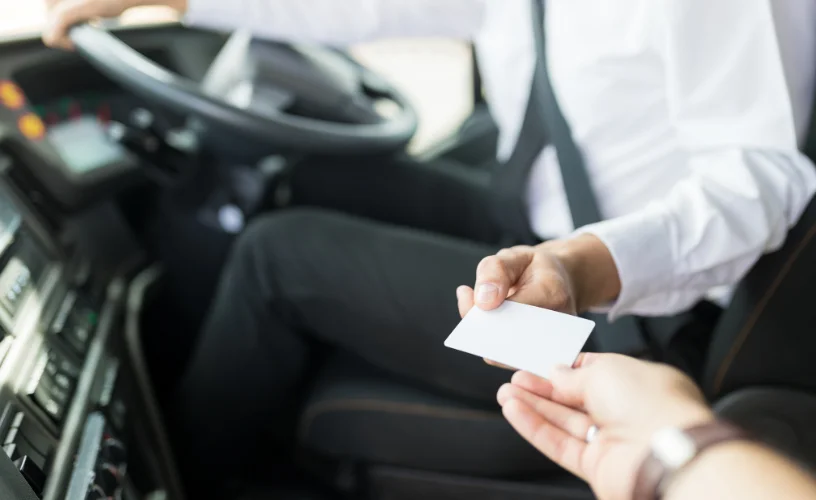 Passenger getting on bus showing ticket