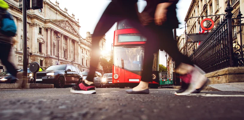 People crossing road as bus approaches in background